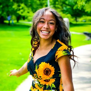 lächelnde Frau im Sonnenblumen Kleid