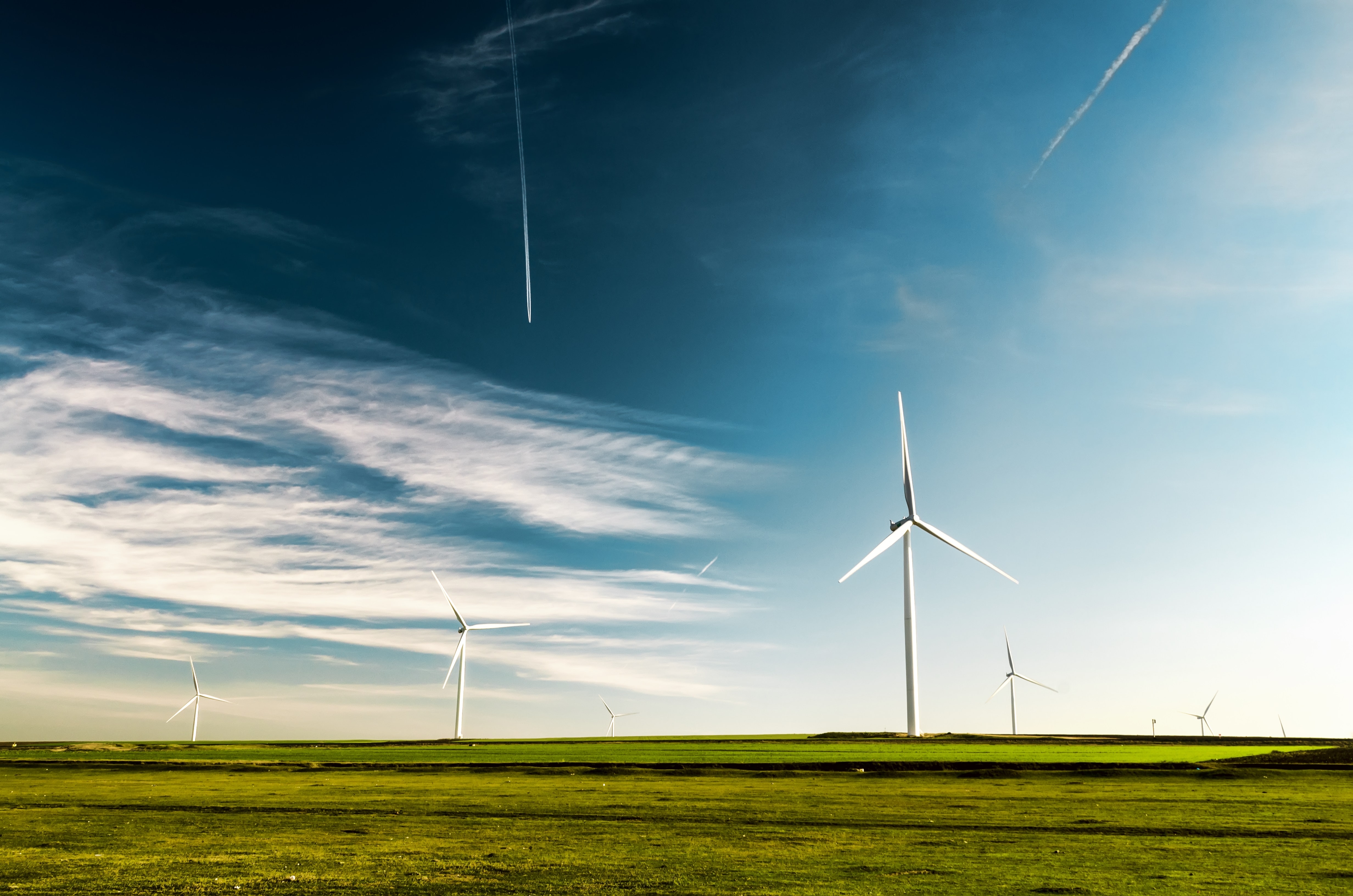 Windräder auf grüner Wiese vor blauem Himmel - Foto von Arteum.ro 