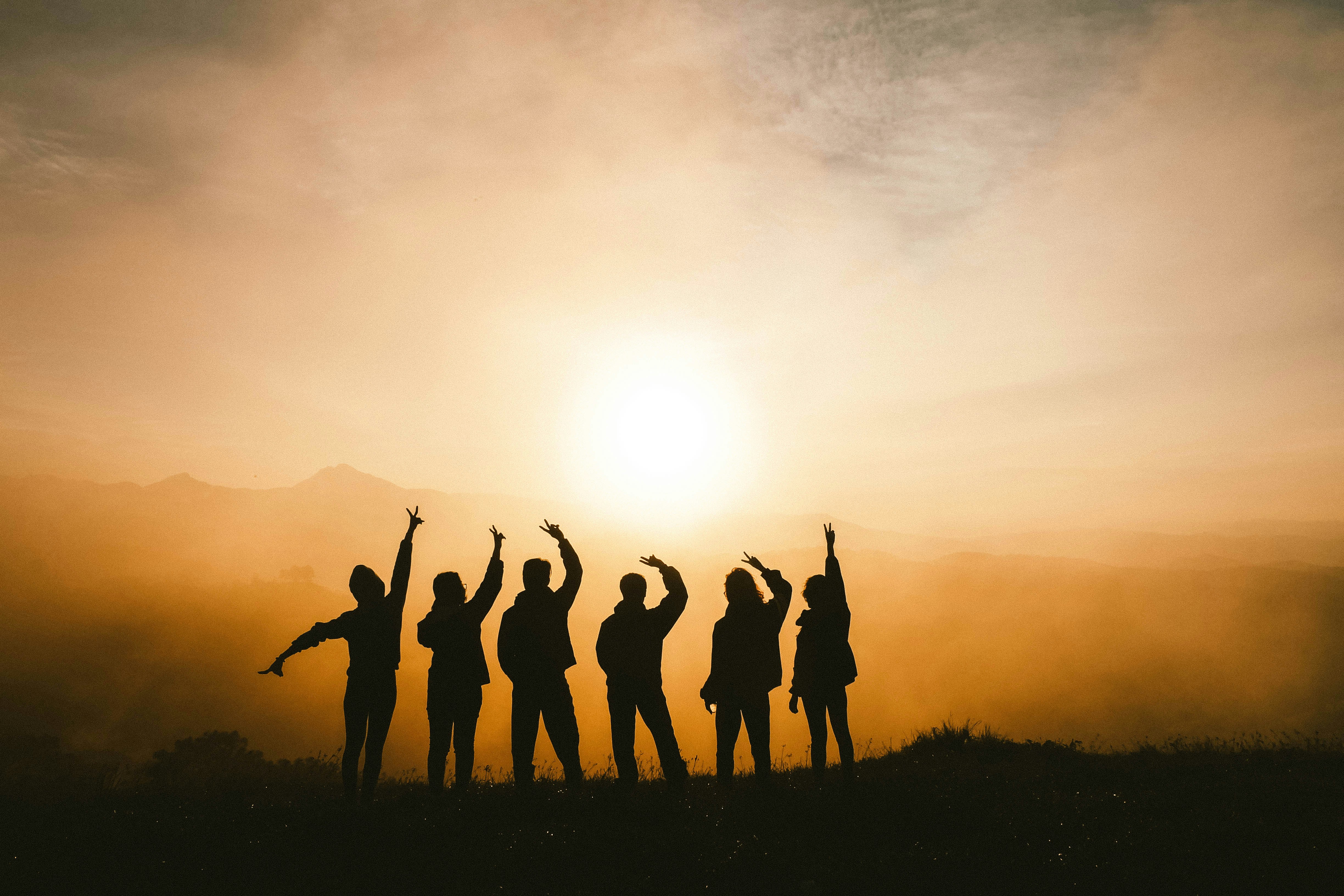Silhouettenfoto von sechs Personen auf dem Gipfel des Berges 